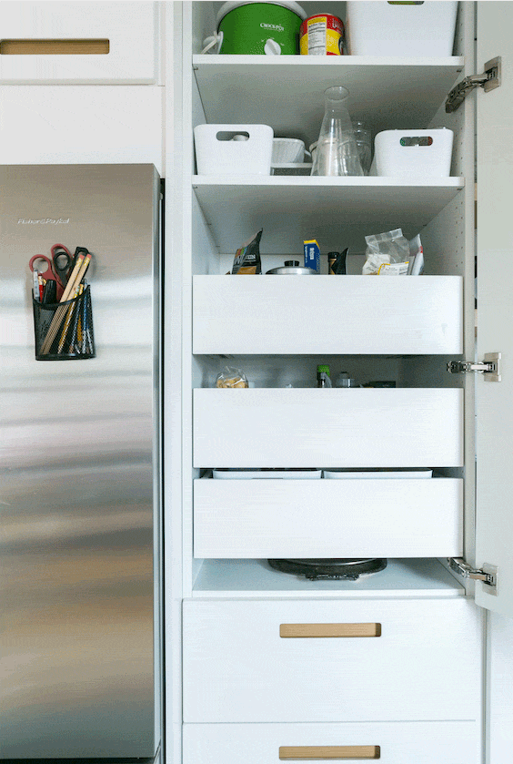 White kitchen storage cabinet with drawers opening and closing