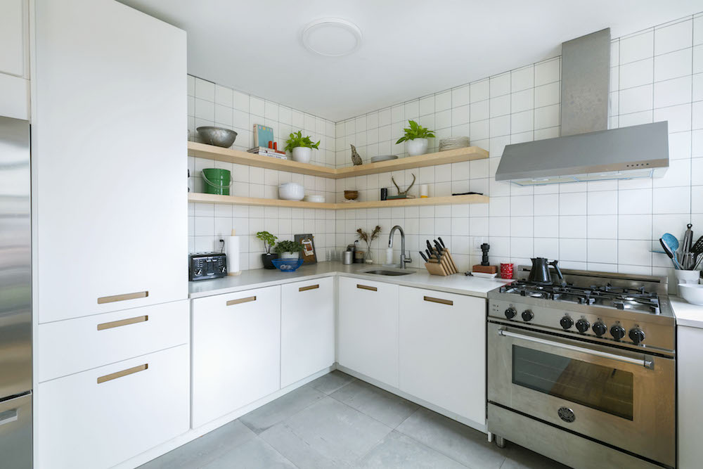 Кухня с белыми шкафами Ikea, плиткой и бытовой техникой из нержавеющей стали.