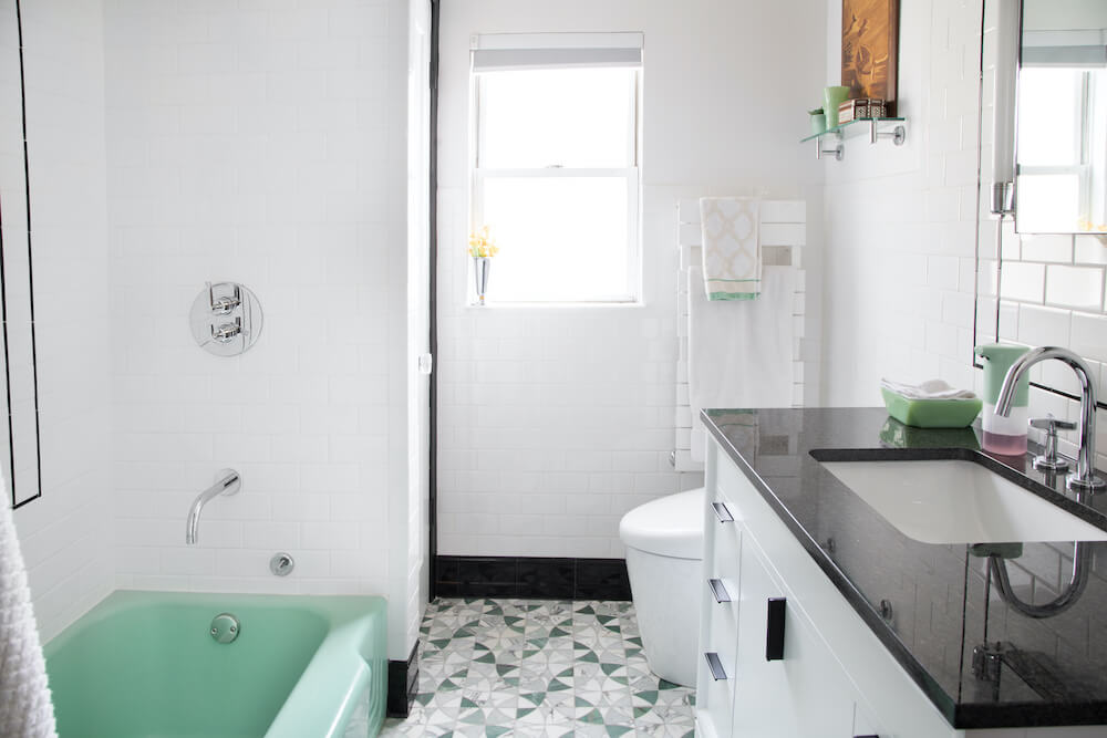 White tiled bathroom with black and green accents