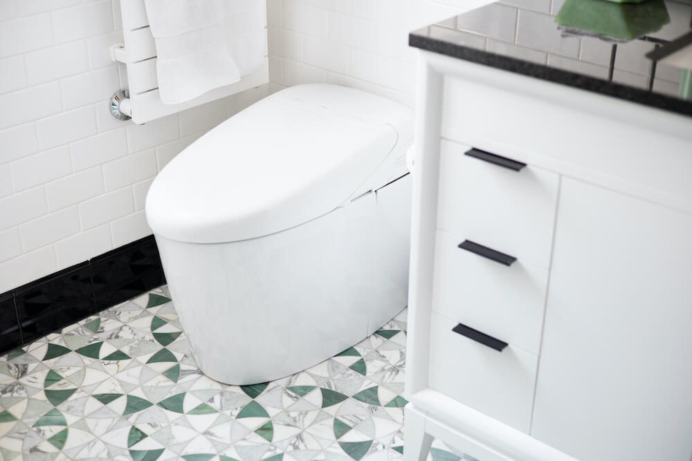 White toilet with art deco floor tiling