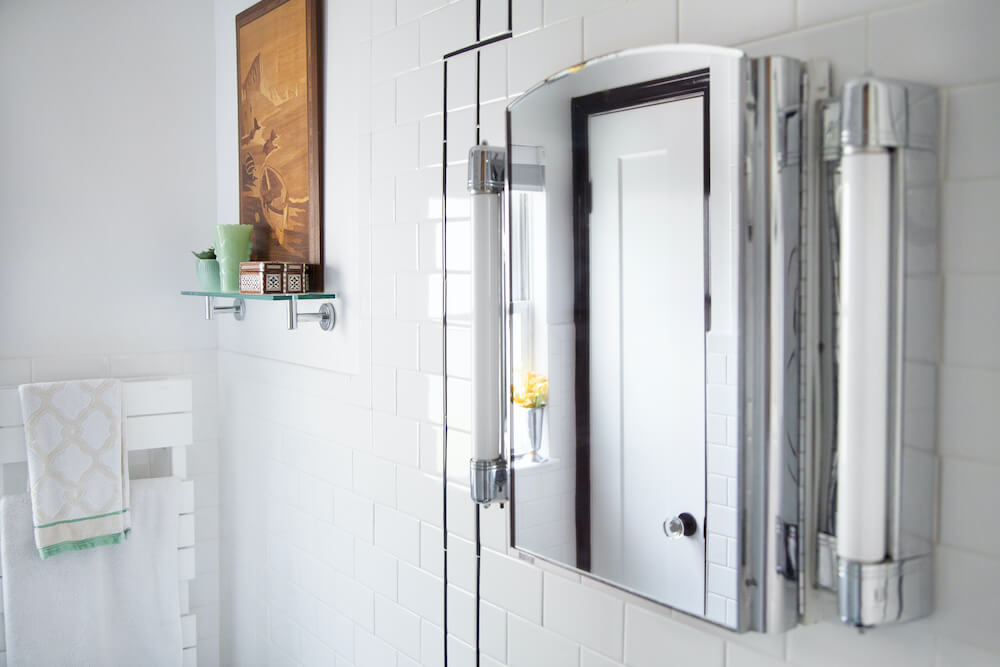 Wall-mounted mirror cabinet flanked with lights