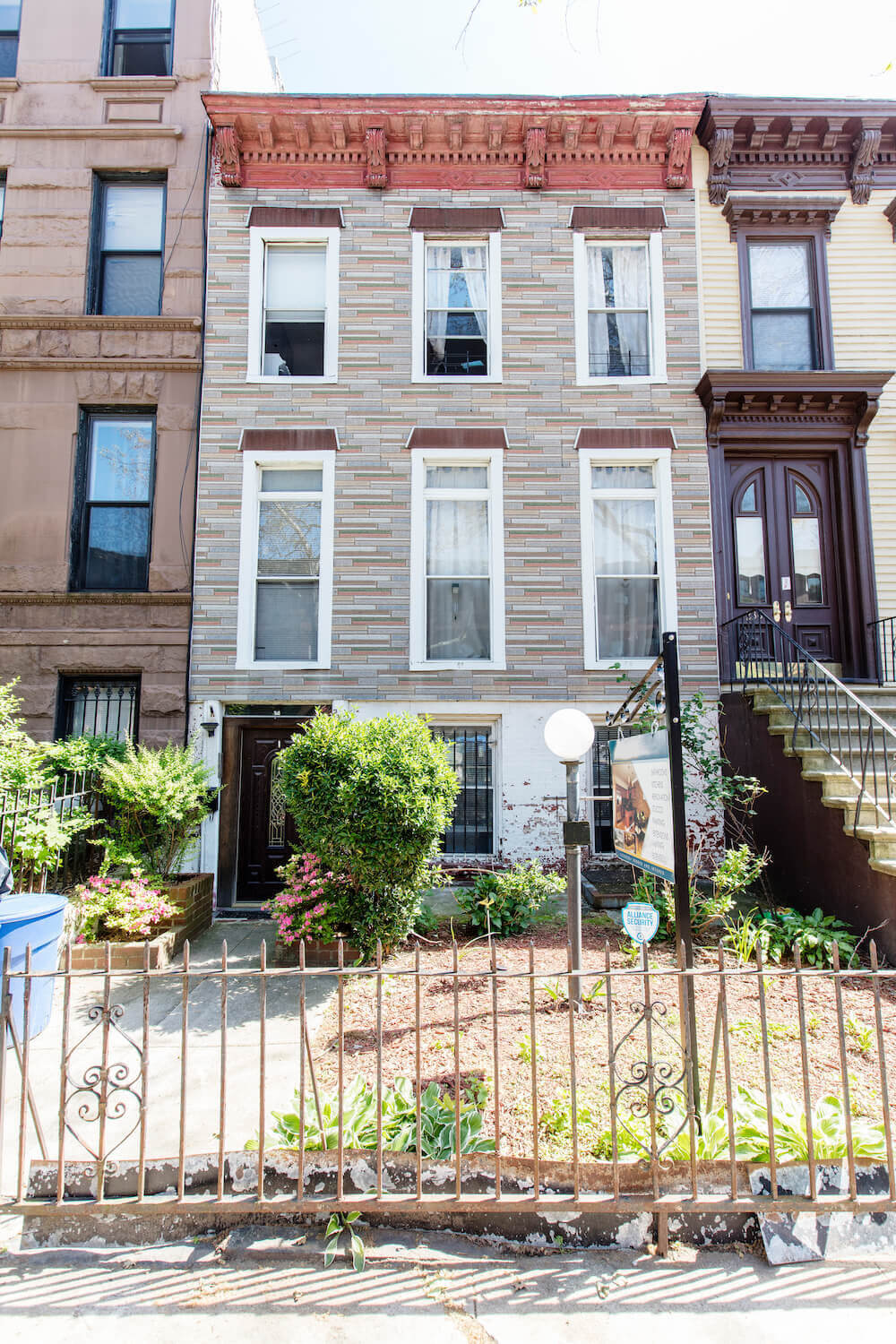 Exterior of the Bed-Stuy home with front yard and metal gate