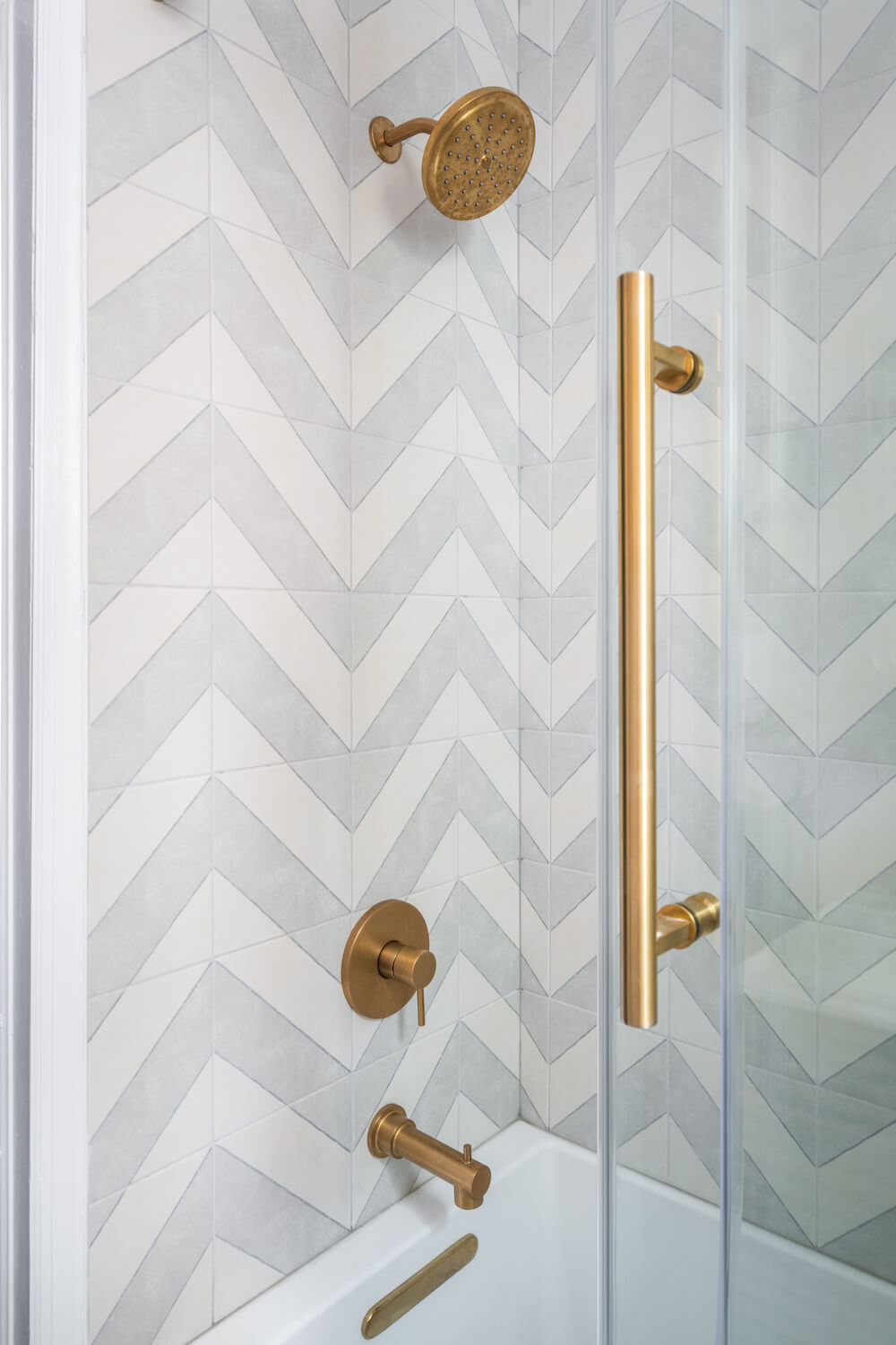 Shower with chevron tiling and bronze hardware