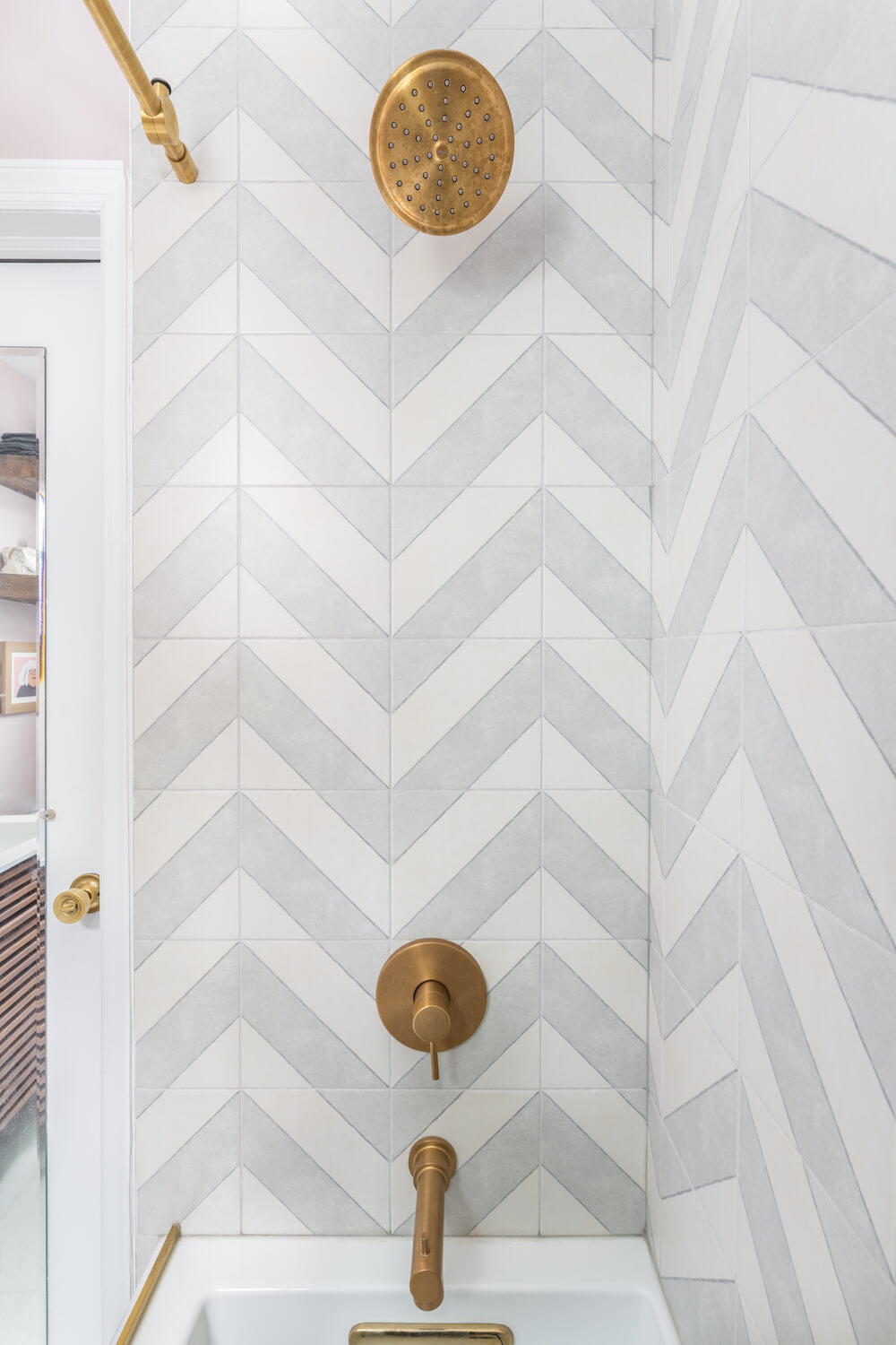 Inside the chevron tiled shower with bronze hardware