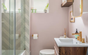 Bathroom with pink walls and wooden vanity