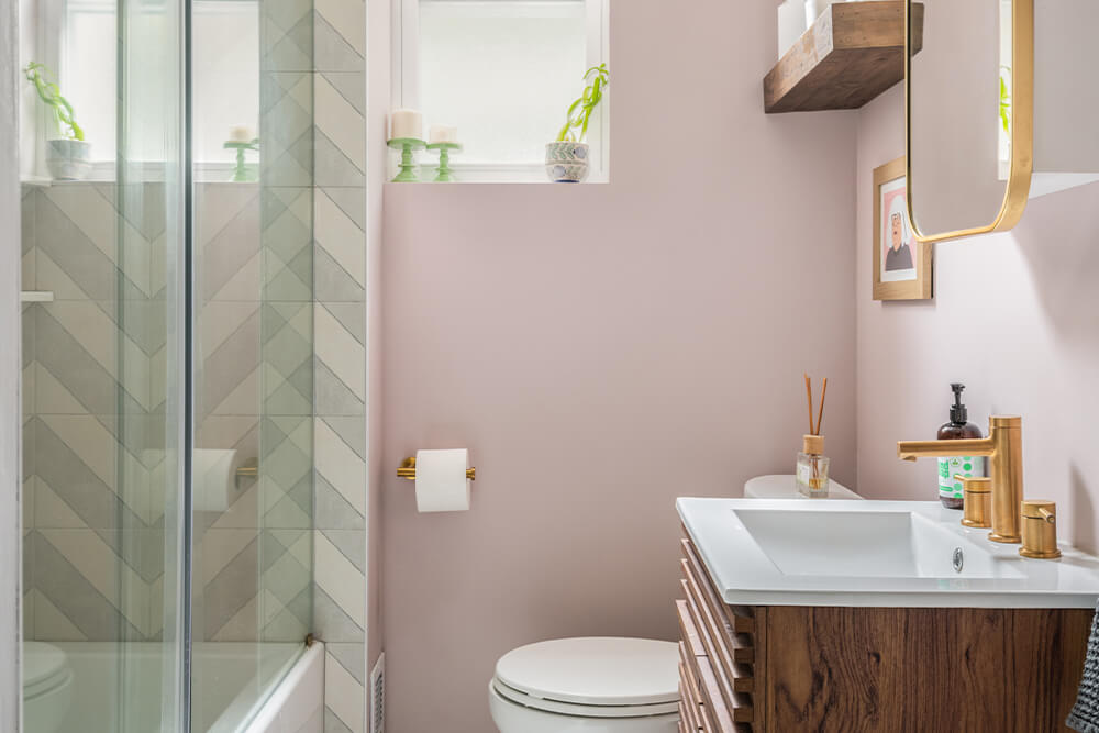 Bathroom with pink walls and wooden vanity