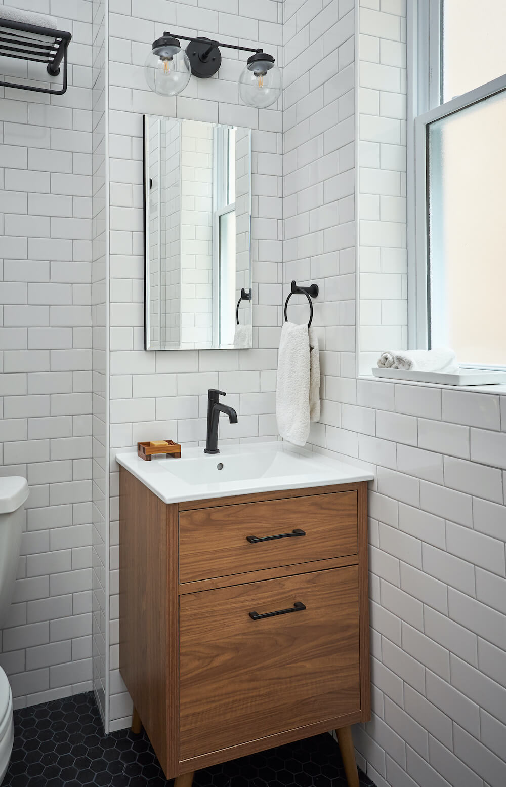 Bathroom with white subway tile and small wooden vanity