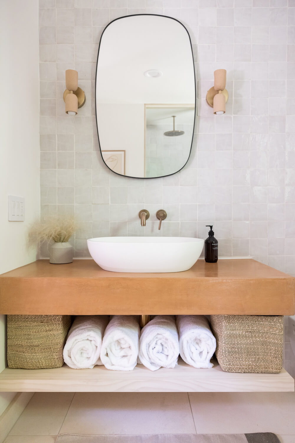 Terracotta bathroom vanity with gray tile walls and freestanding sink