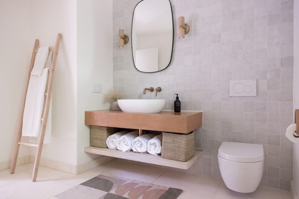 Terracotta bath vanity with storage and a floating toilet