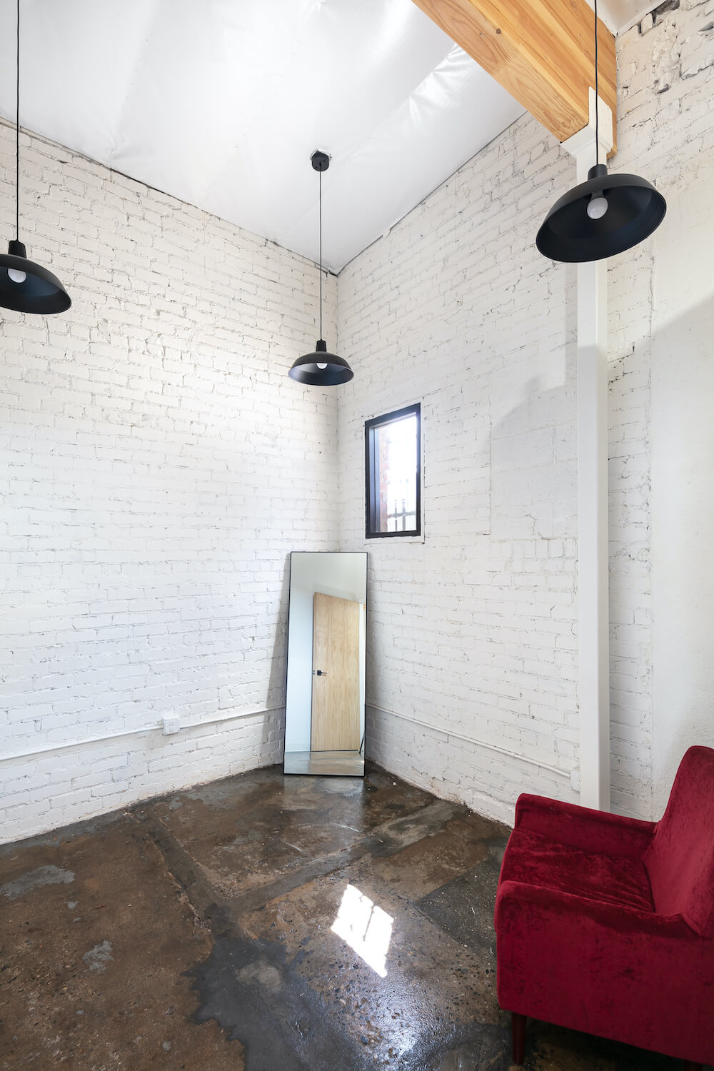 Room with painted brick and hanging black lamps