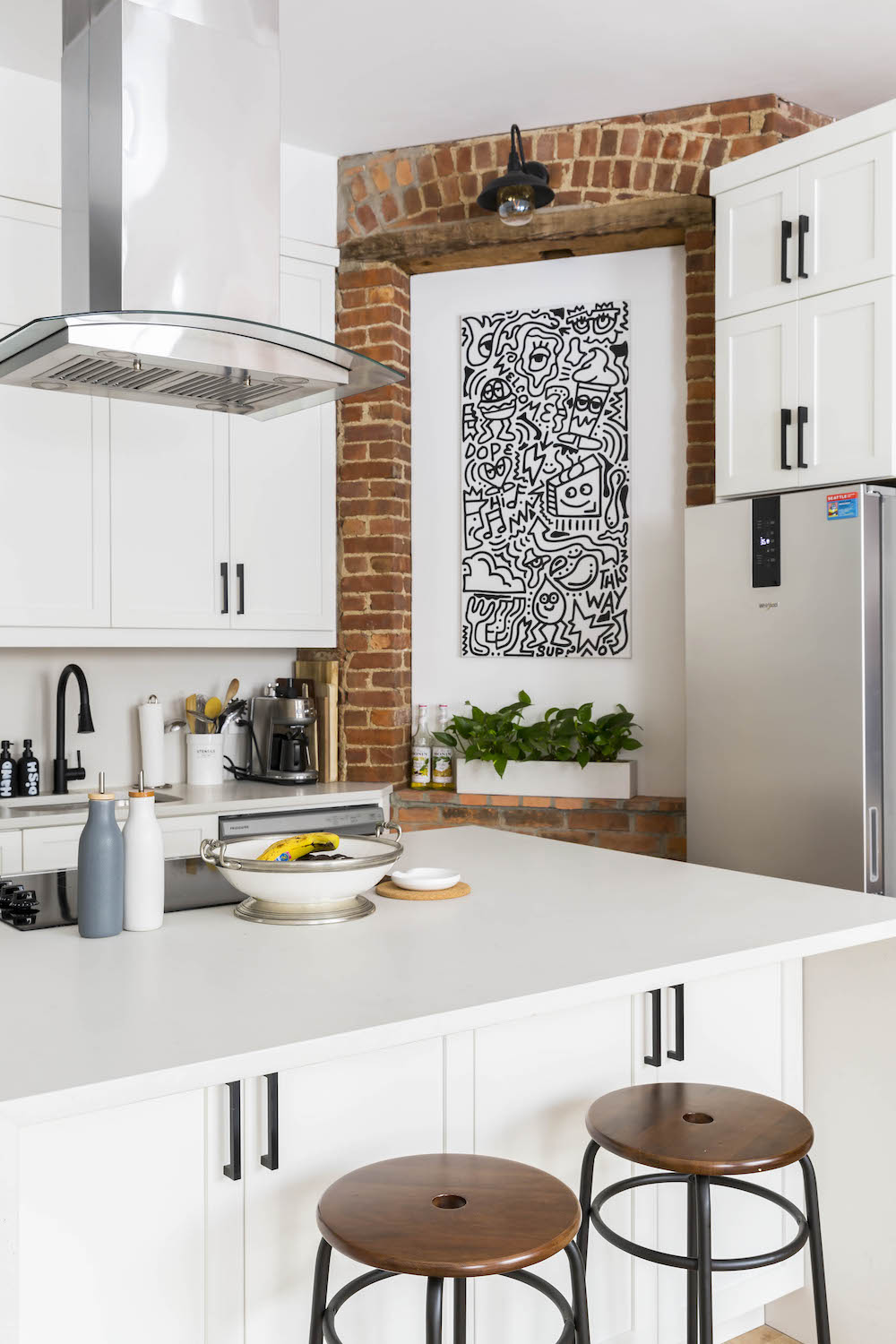 Kitchen island with art hanging on brick wall behind