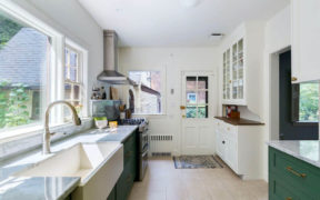 green kitchen cabinets with door leading outside