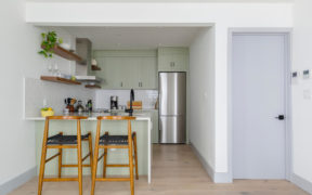 sage green kitchen with bar seating at peninsula