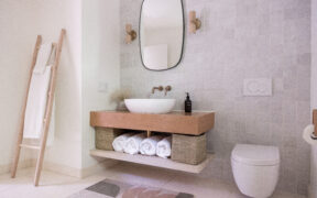 Soft gray zellige tile brings handcrafted texture to David’s minimalist bath, pairing warm wood vanity and ladder storage for a spa feel at home.