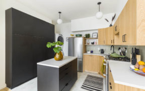 Kitchen with black island and ceiling height storage