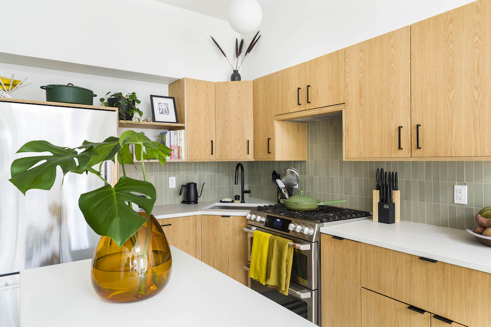 Remodeled kitchen with wood kitchen cabinets and sage green backsplash