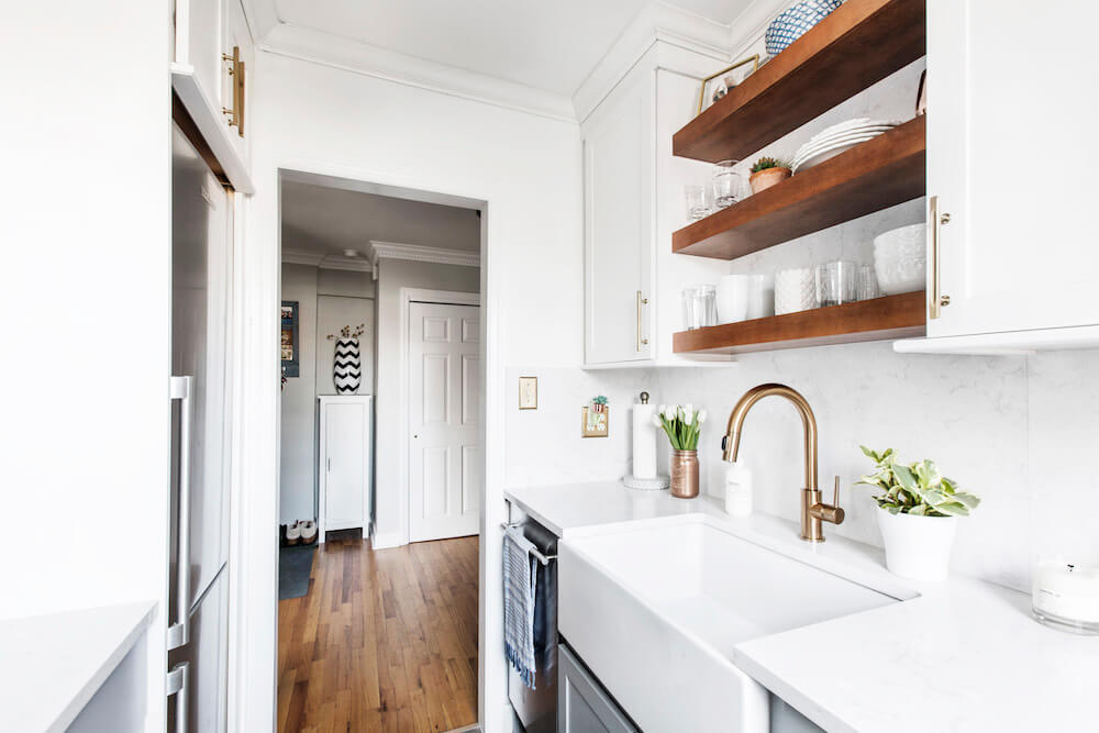 Large white kitchen sink with gold faucet