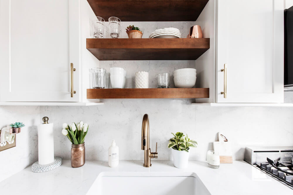Large white kitchen sink with gold faucet