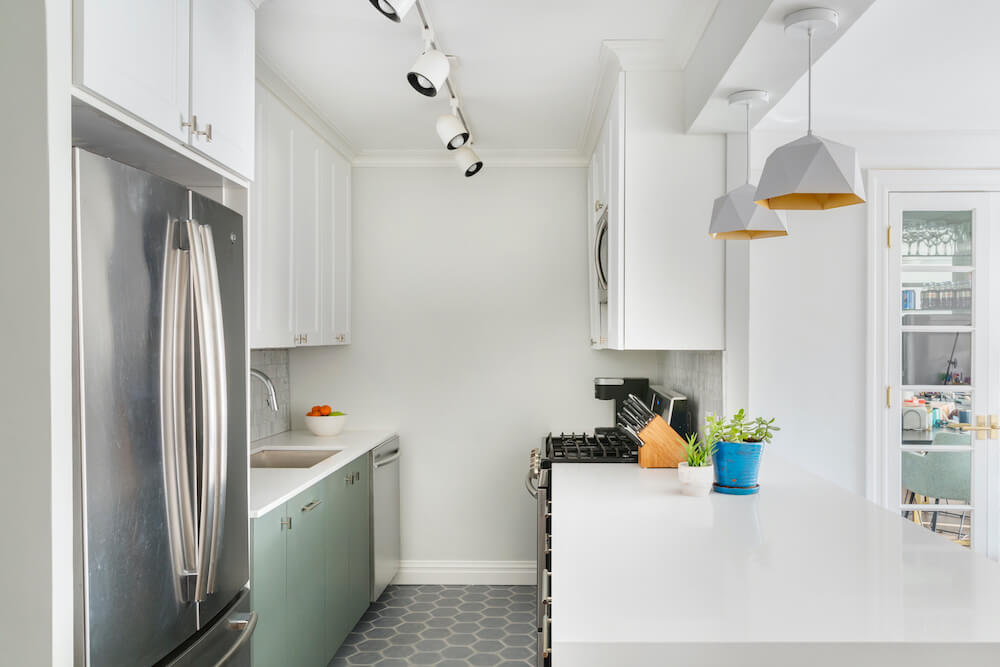 Open plan galley white and sage green kitchen