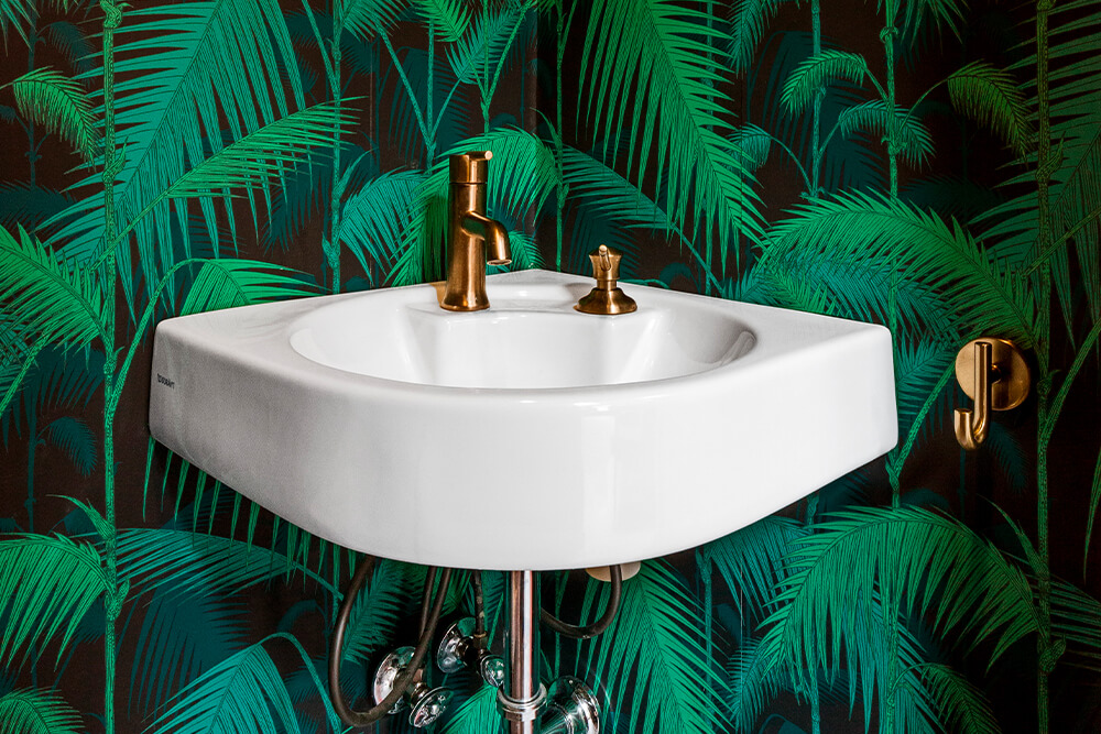 Bathroom sink with leafy wallpaper