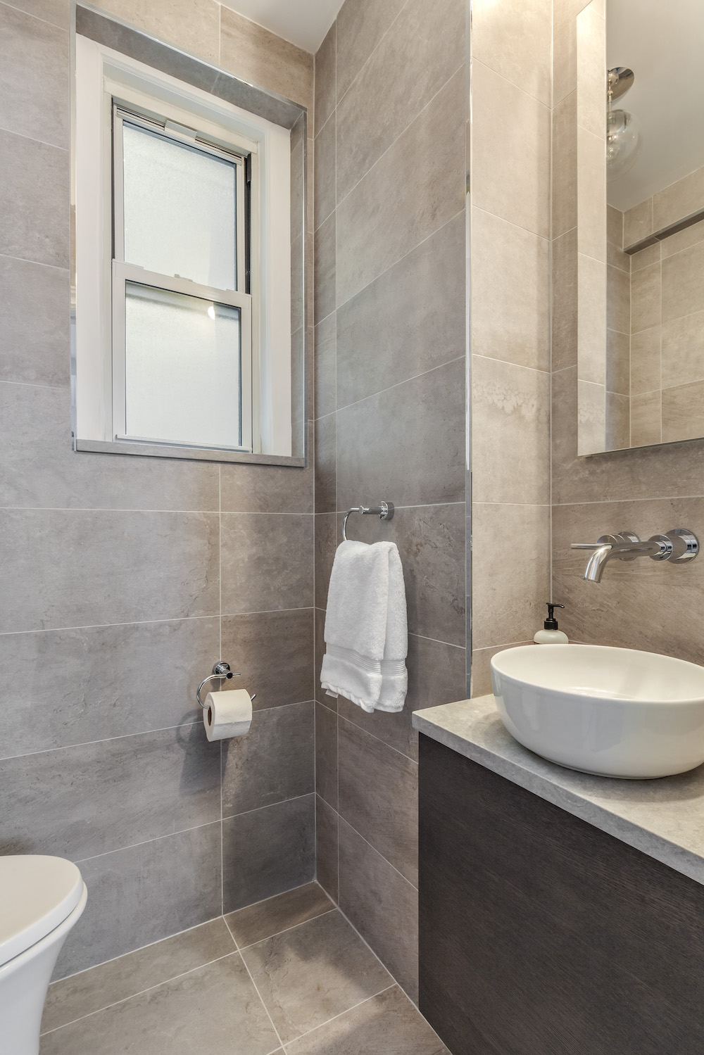 Stone tiled bathroom with custom vanity