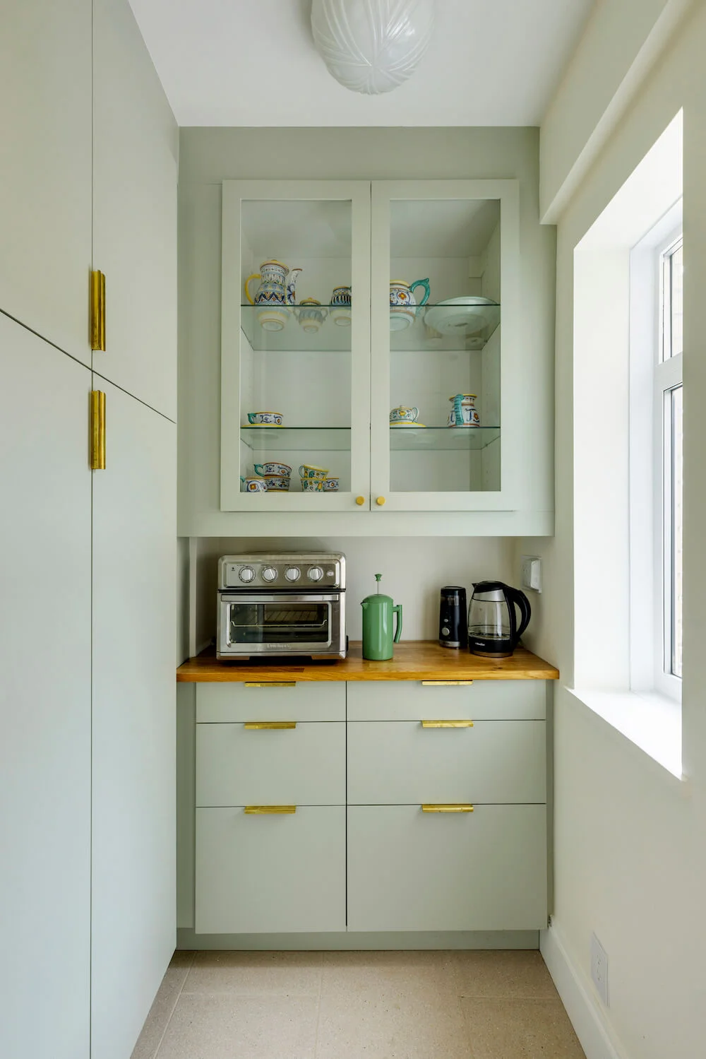 green Ikea kitchen pantry in apartment remodel on the upper west side