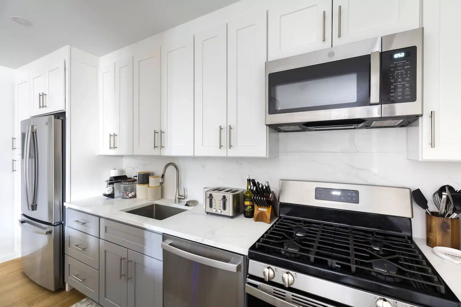 white and gray kitchen cabinets with marble look backsplash