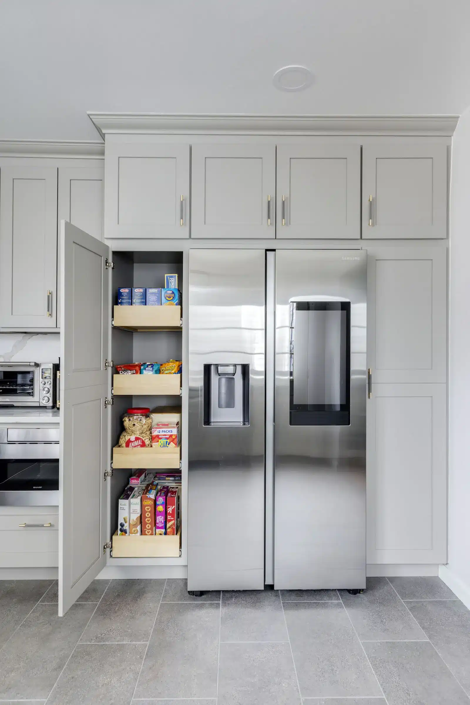 gray cabinet pantry next to refrigerator in home remodel in rosedale