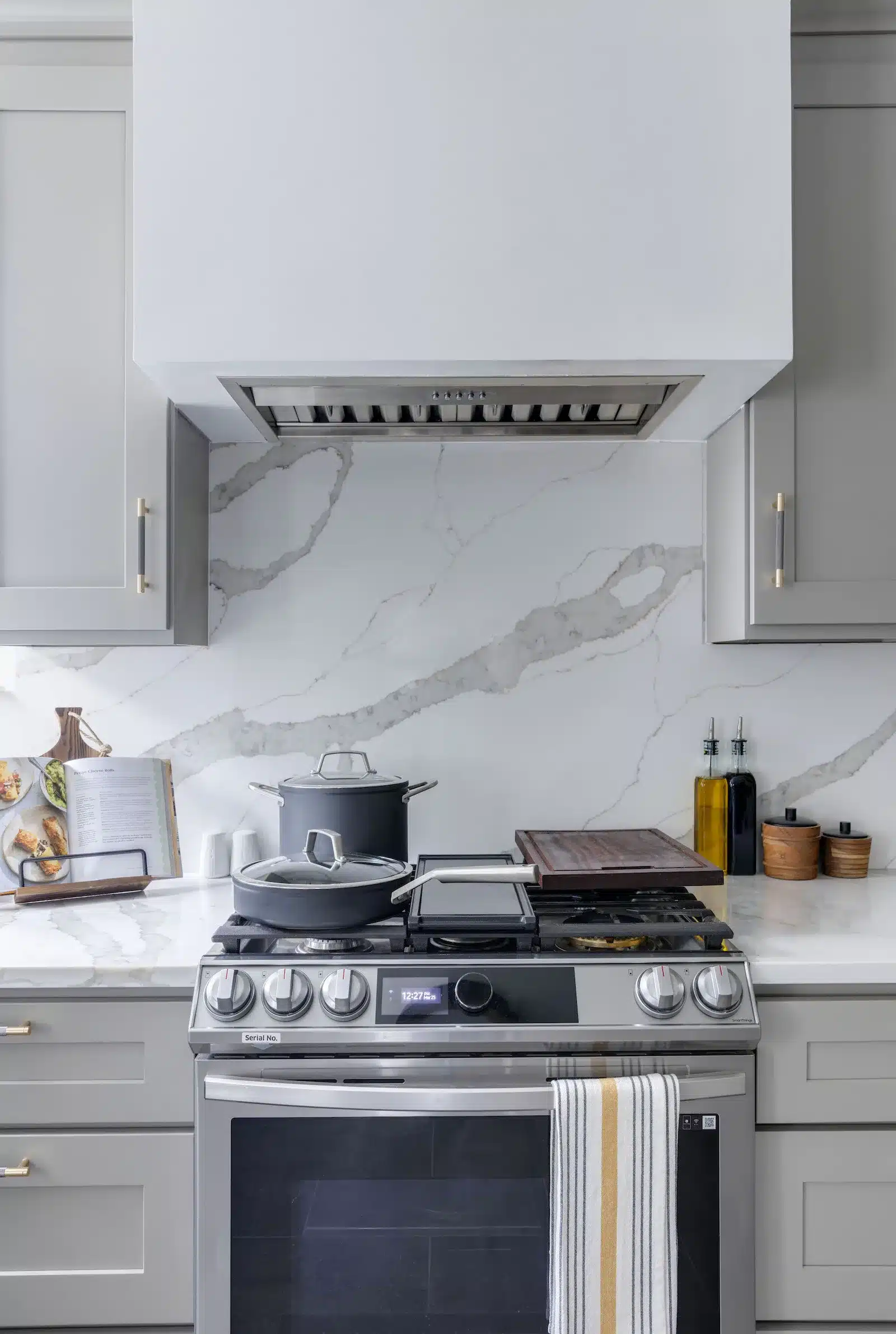 stove with gray kitchen cabinets and marble quartz