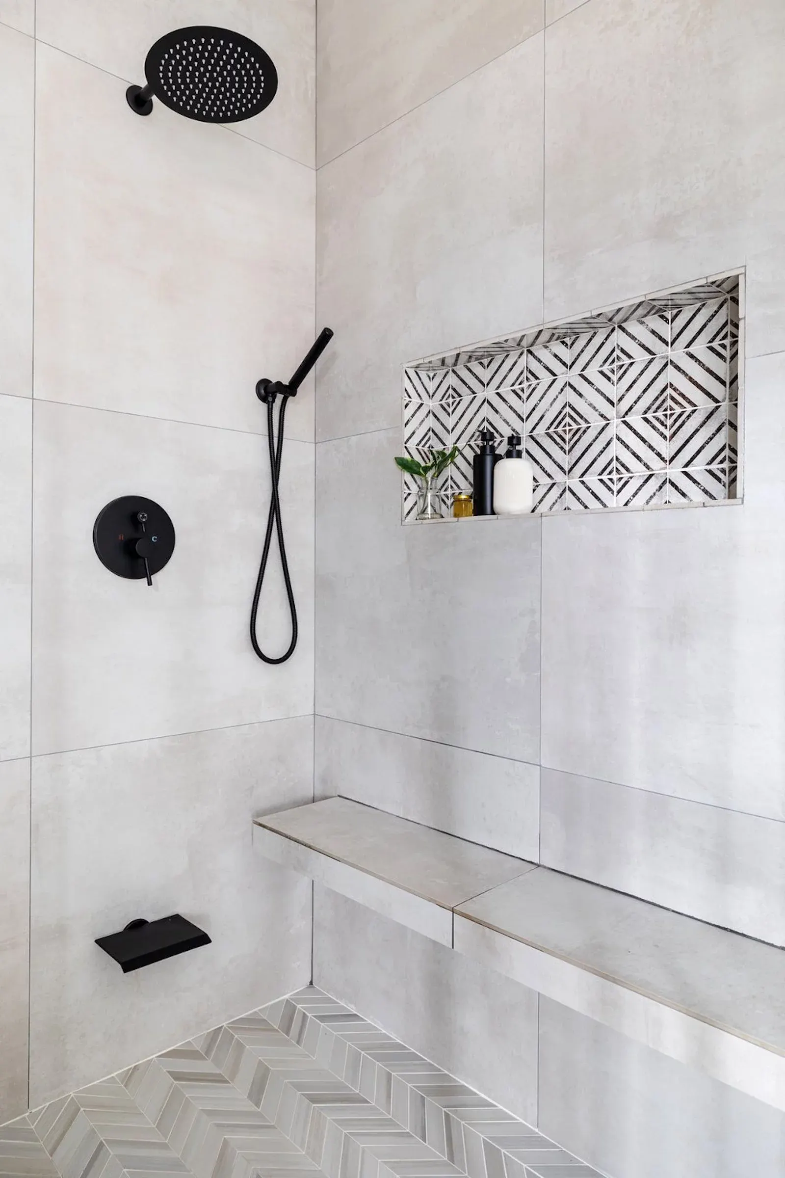 shower with gray tile and shower seat and tiled shower niche