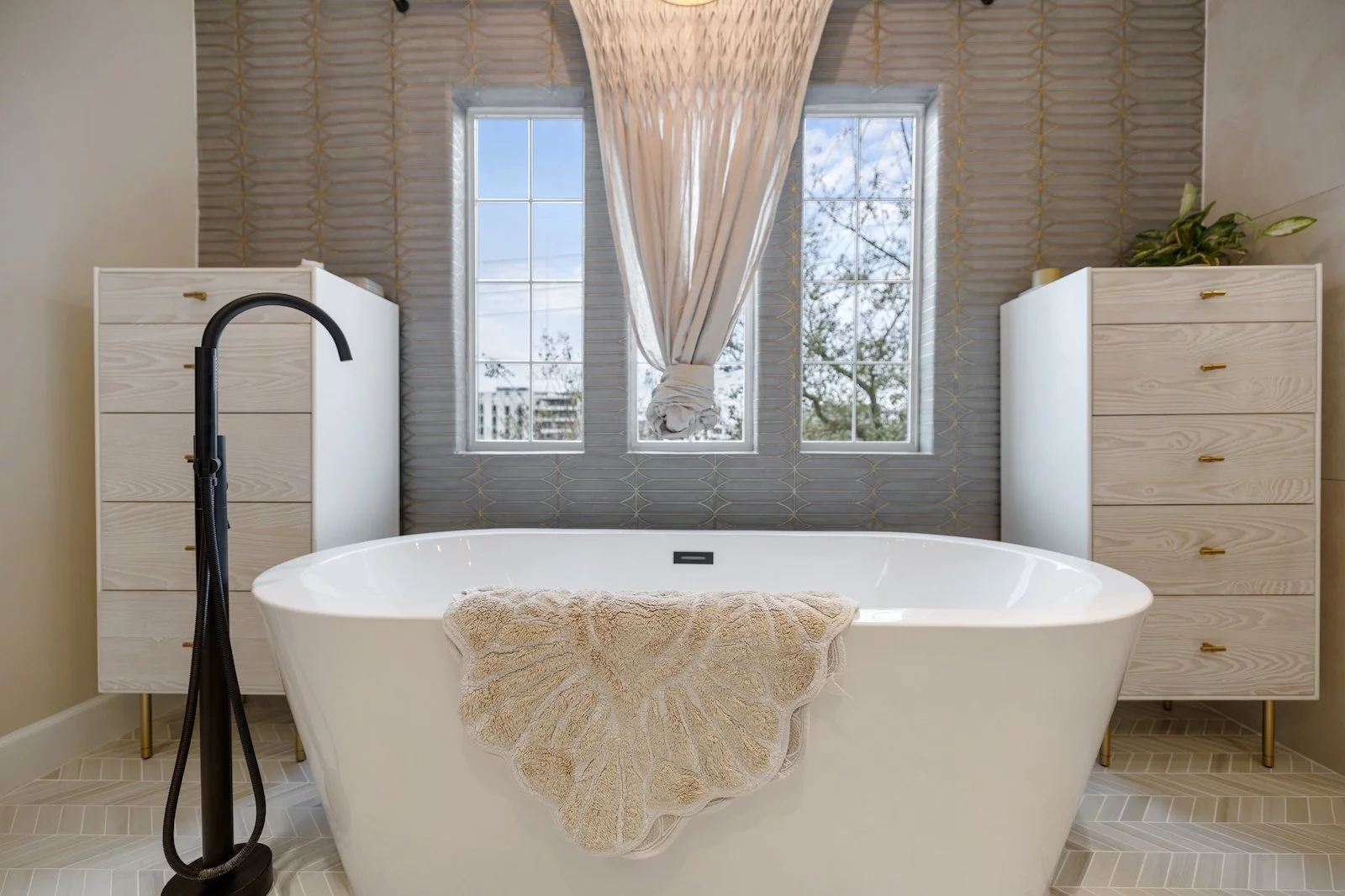 freestanding soaking tub with tub filler and storage cabinets