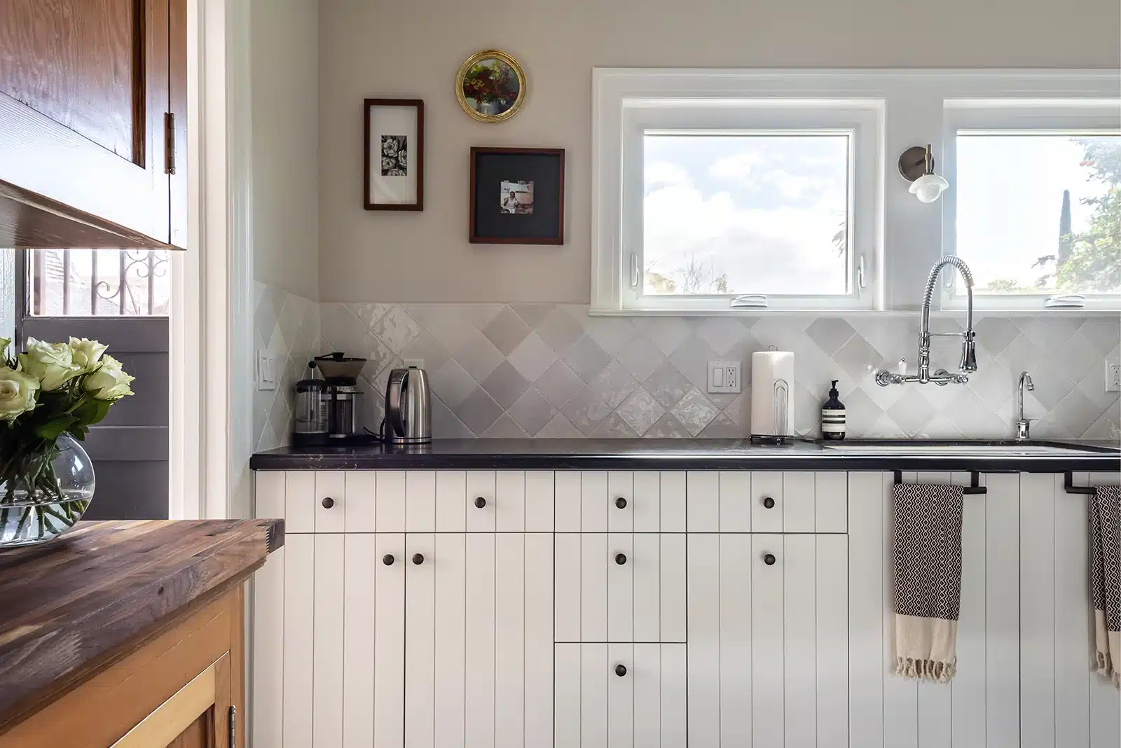 white beadboard cabinet doors with black hardware and countertop in kitchen remodel