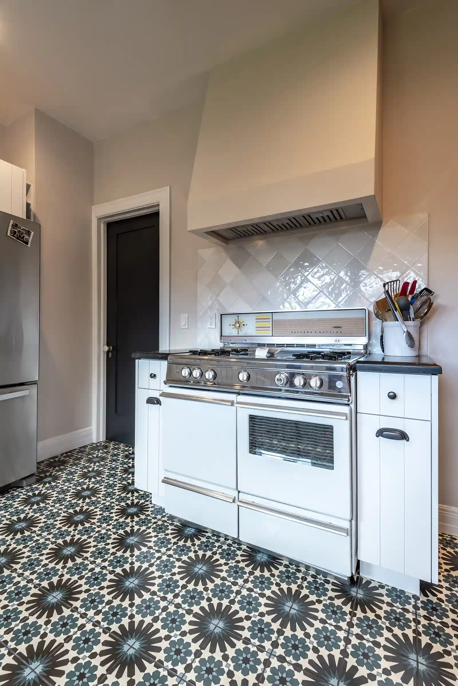 kitchen with white stove and patterned floor tile in home remodel in mid city