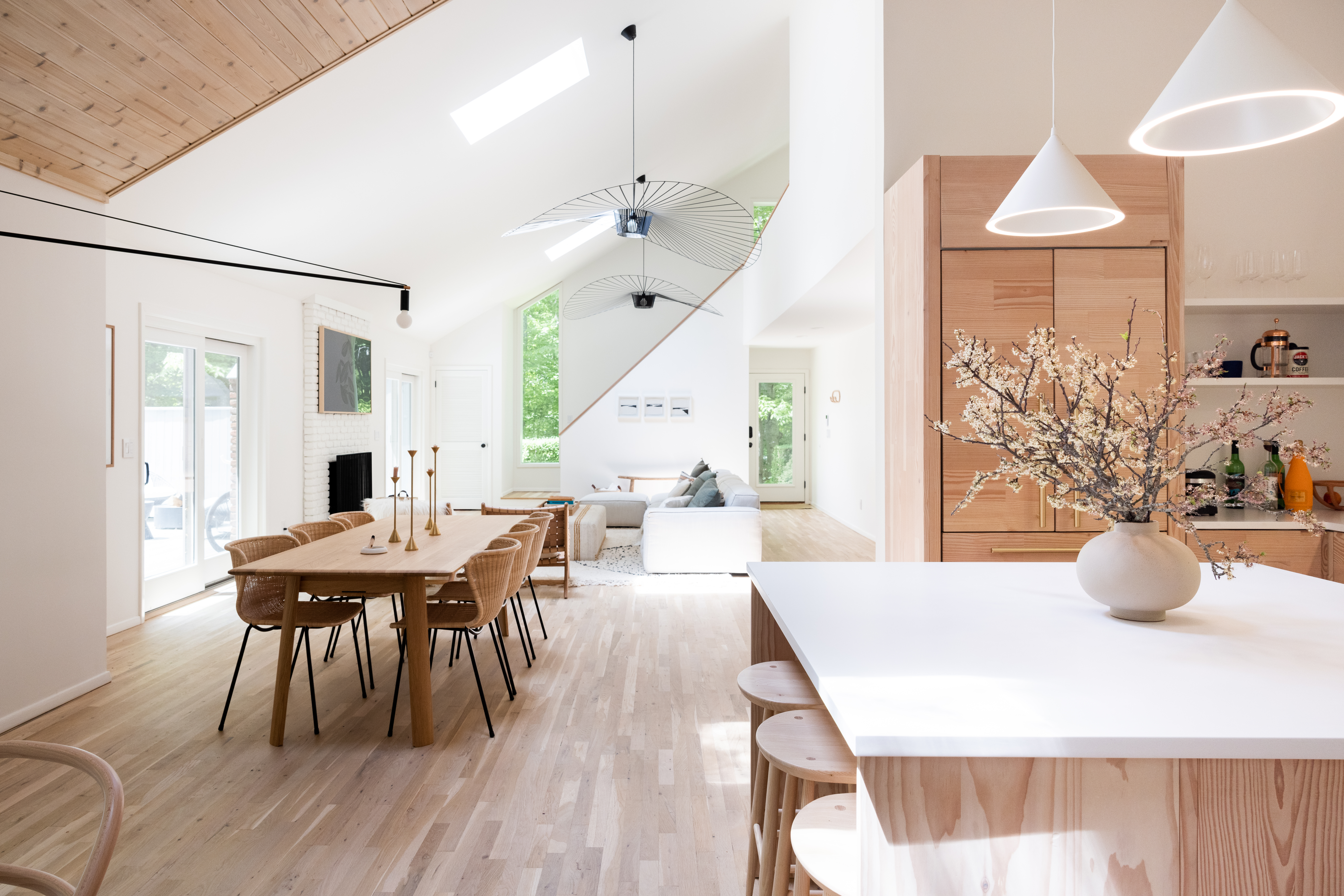 Bright kitchen with wooden floor tiles, wood-tone kitchen island, and wooden cabinets.