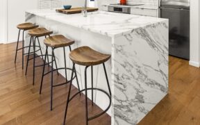 Calacatta marble kitchen island with wooden seating and flooring