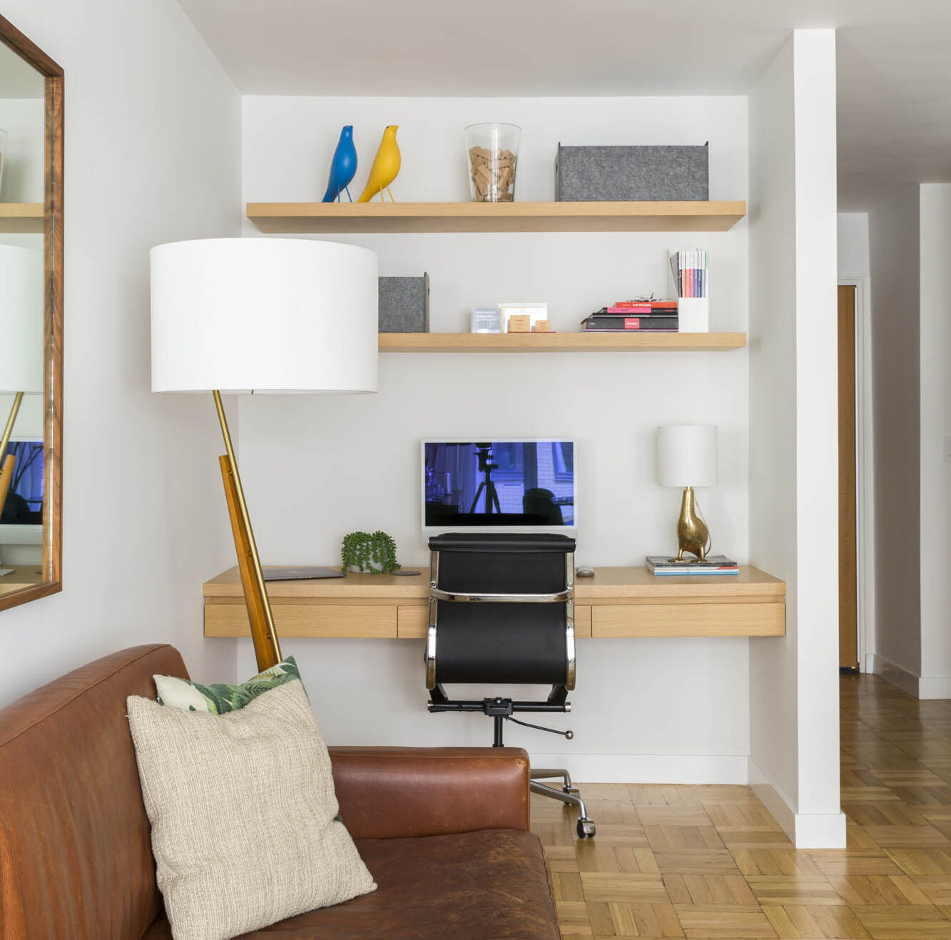 Home office niche with wood shelves and modern desk in mid-century Manhattan living room renovation.