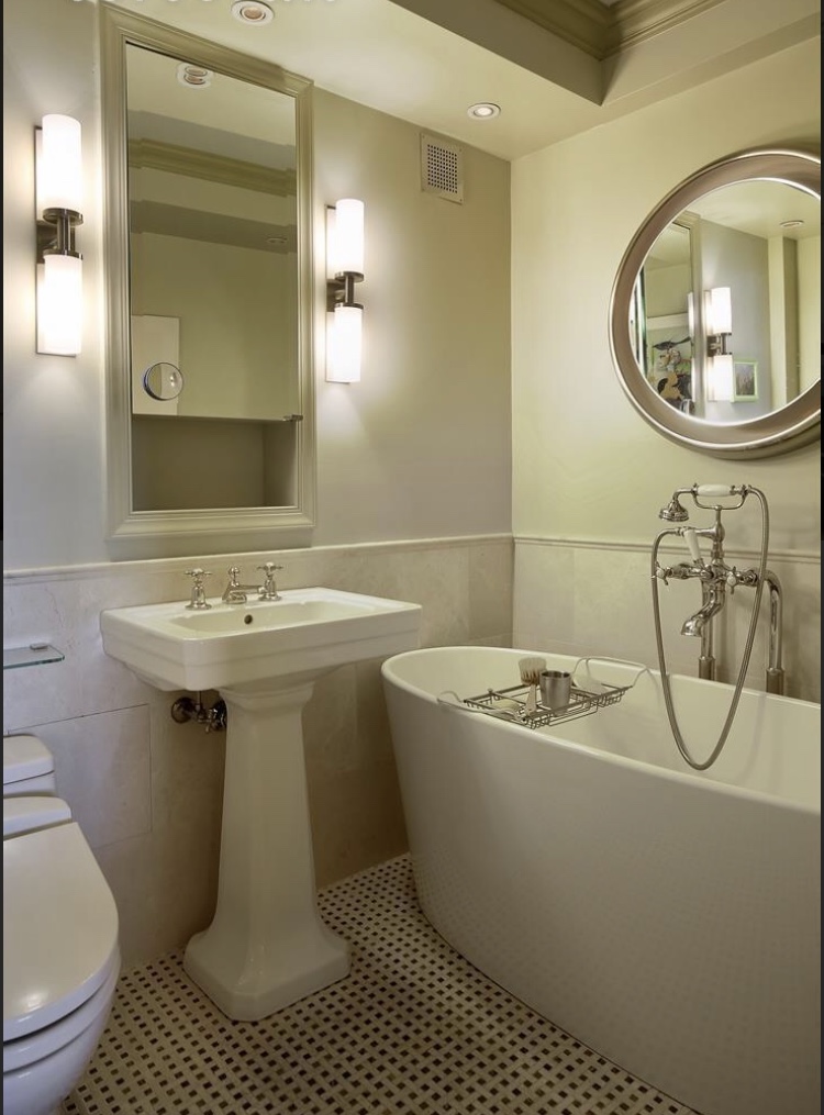 Before image of a white bathtub and vanity prior to a tub to shower renovation.