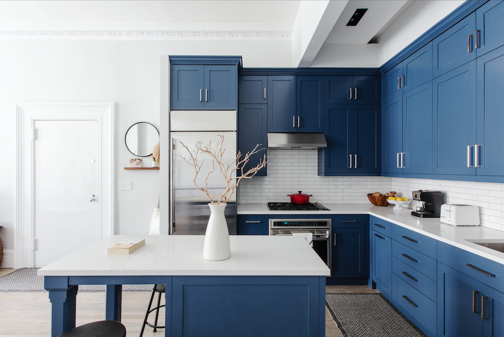 Crisp blue cabinetry and white counters bring clean lines and bright contrast to this classic, modern kitchen.