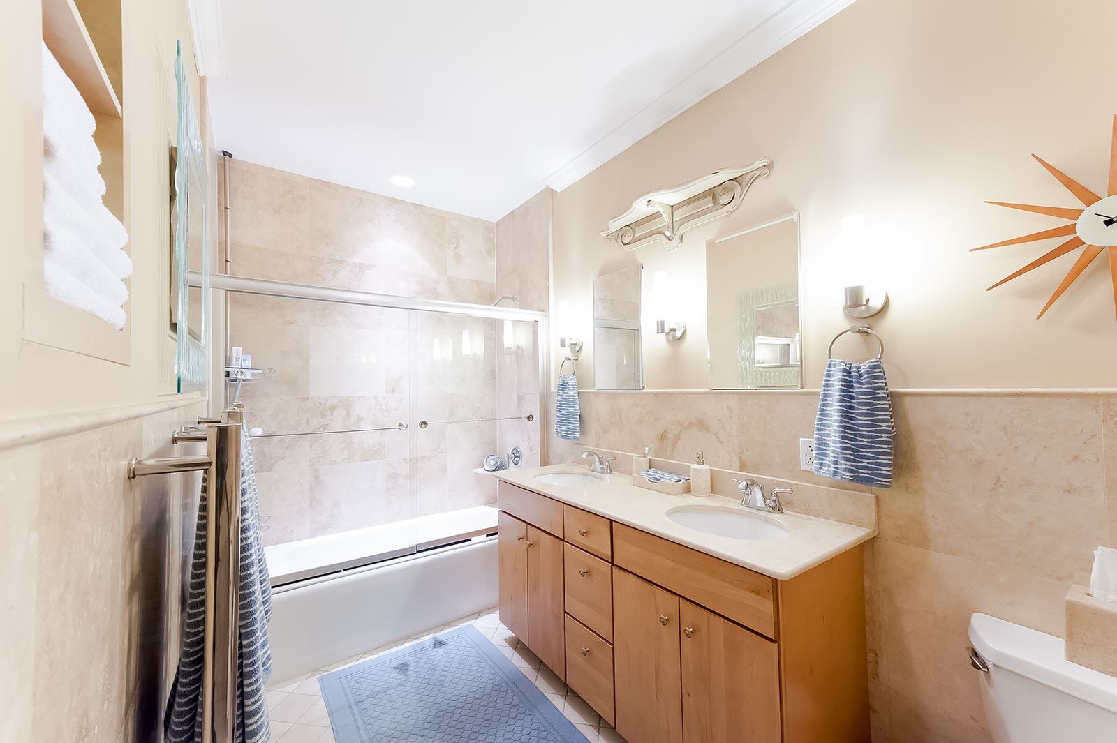 Bathtub and wooden vanity before a tub to shower conversion remodel.