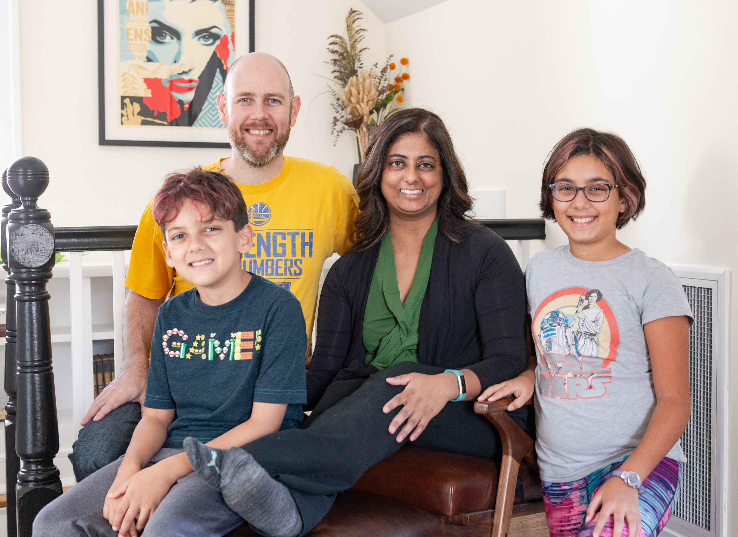 A man and a woman with two kids sitting at the hallway of their newly renovated attic.