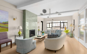 Renovated city living room with updated flooring, modern lighting, and reworked seating layout that improves flow, comfort, and everyday usability.