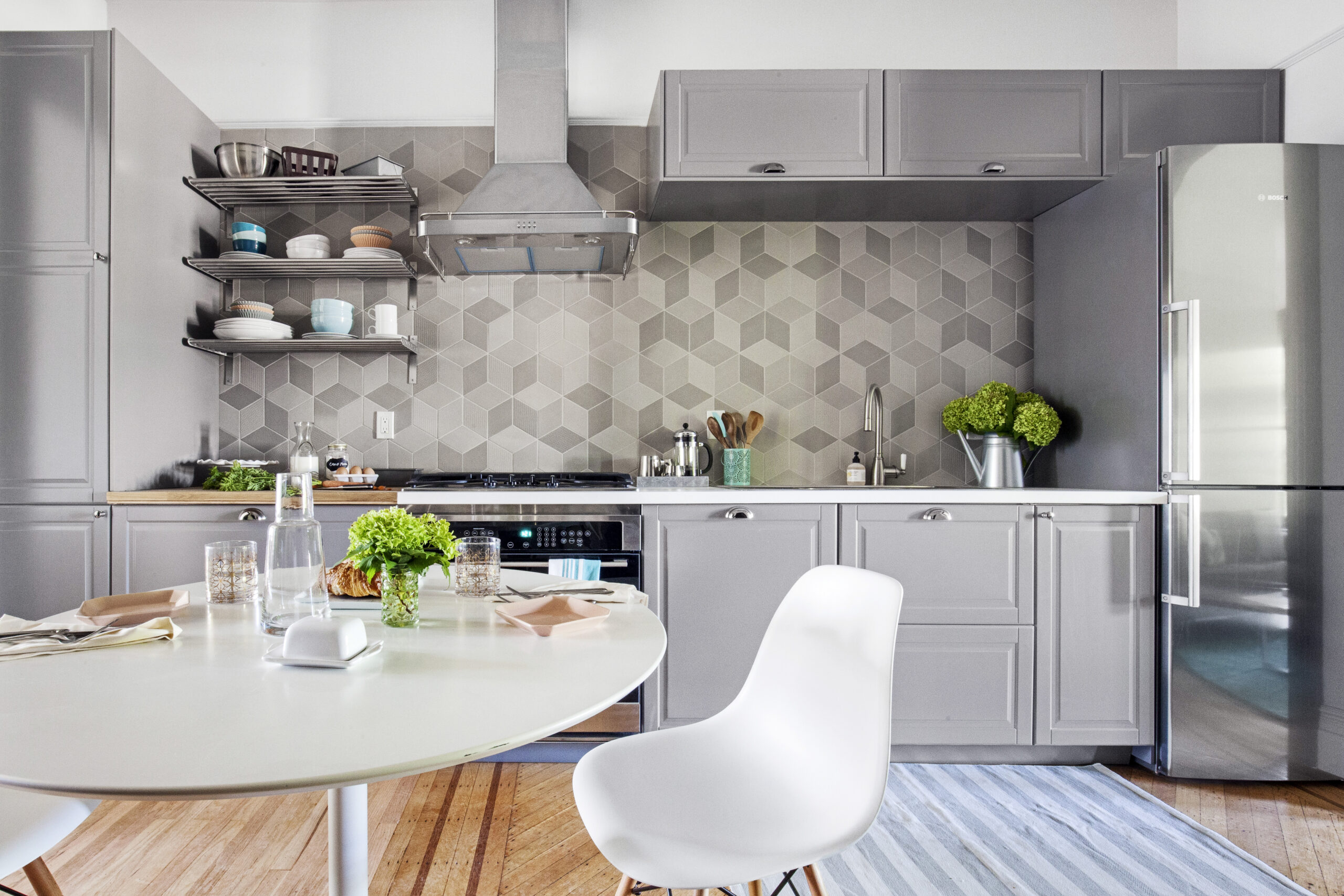 Renovated kitchen of a historic brownstone renovation in Crown Heights with wooden flooring and hex backsplash.