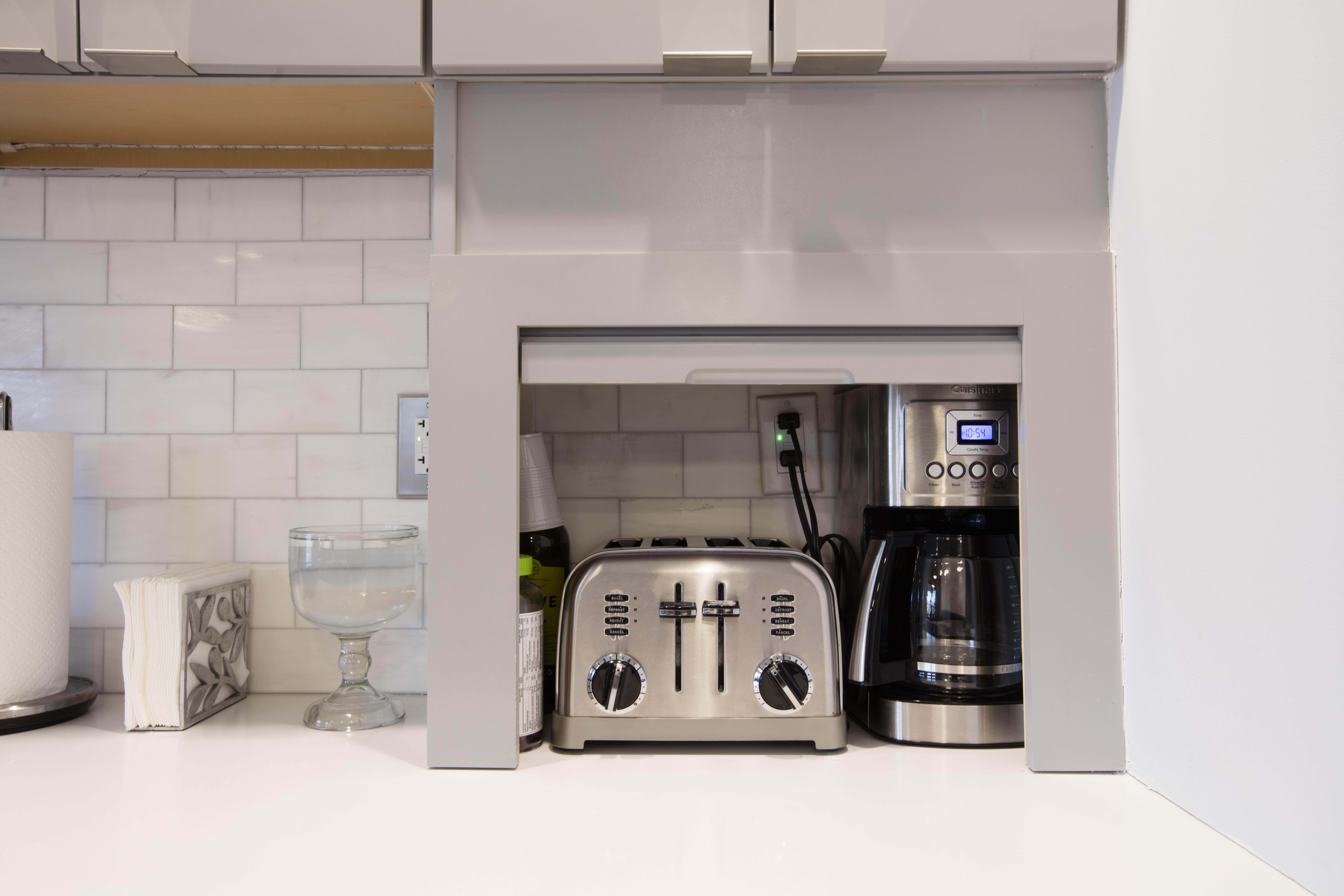 Appliance garage with toaster and coffee maker tucked behind a lift door, keeping counters clear for holiday hosting and easy entertaining with guests nearby.