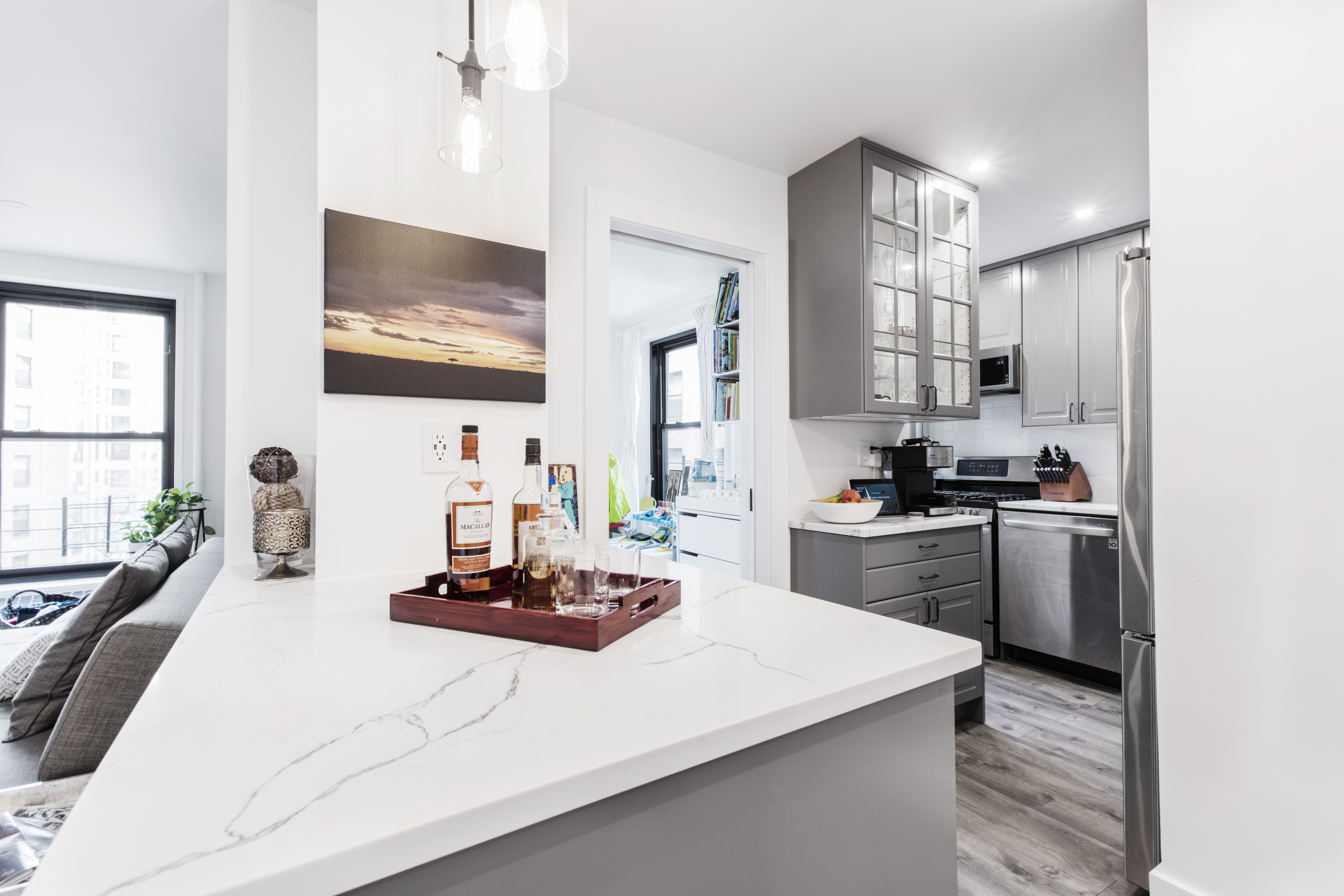 Peninsula bar with drink tray and pendant lights near living area; layout keeps holiday guests out of the cook lane for easy entertaining.