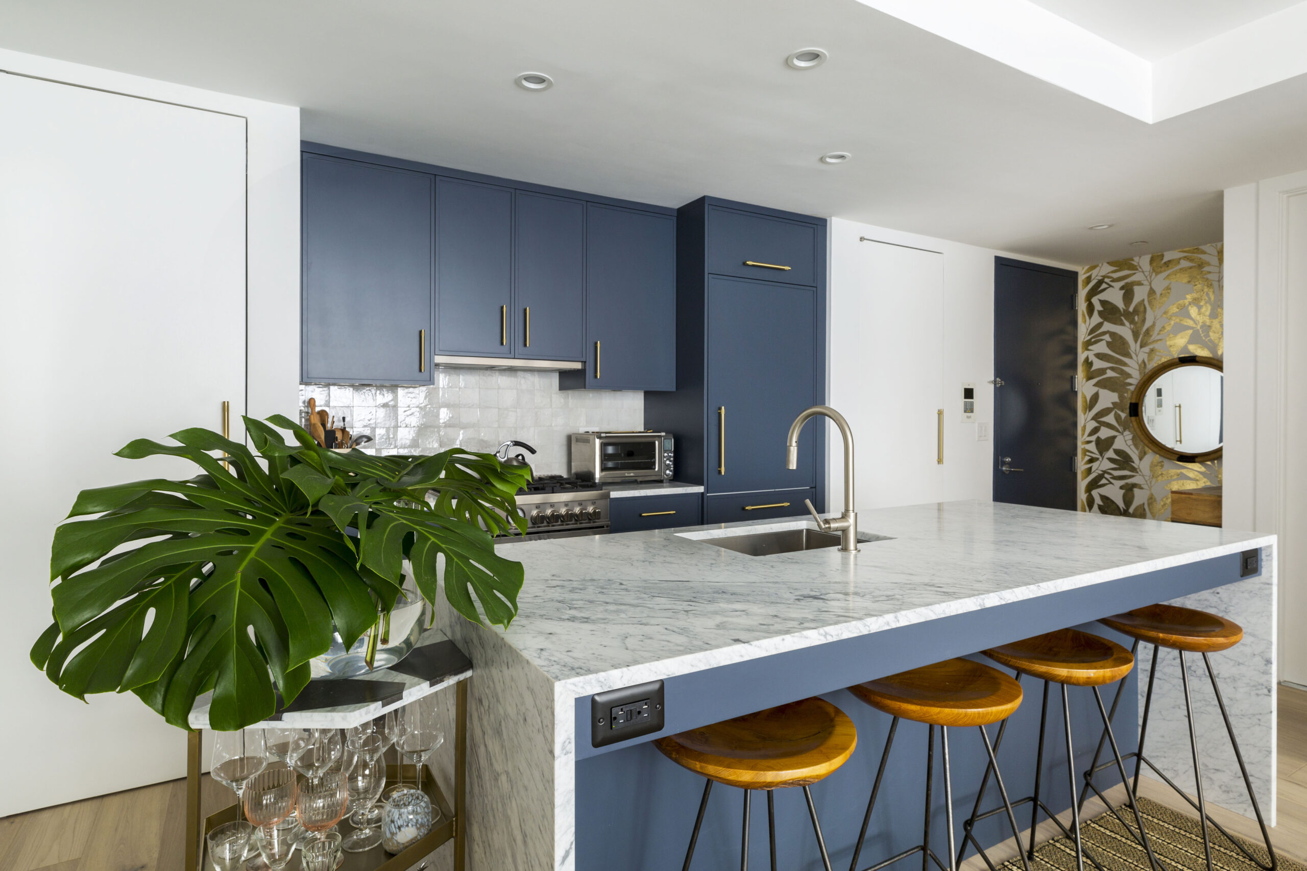 Kitchen with blue slim Shaker cabinets, quartz island, and wooden seating
