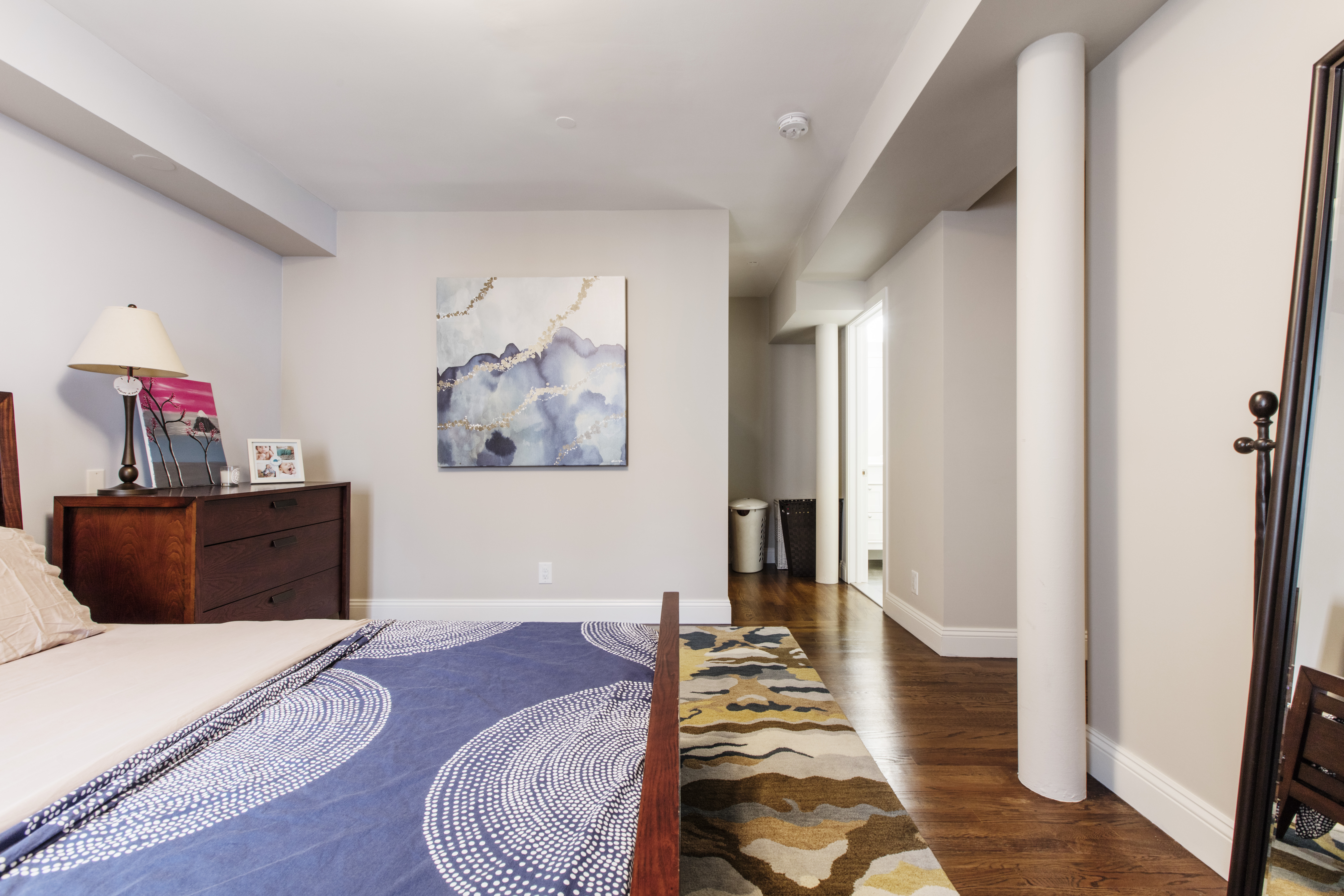 A renovated Tribeca master bedroom with cream wall color and wooden flooring