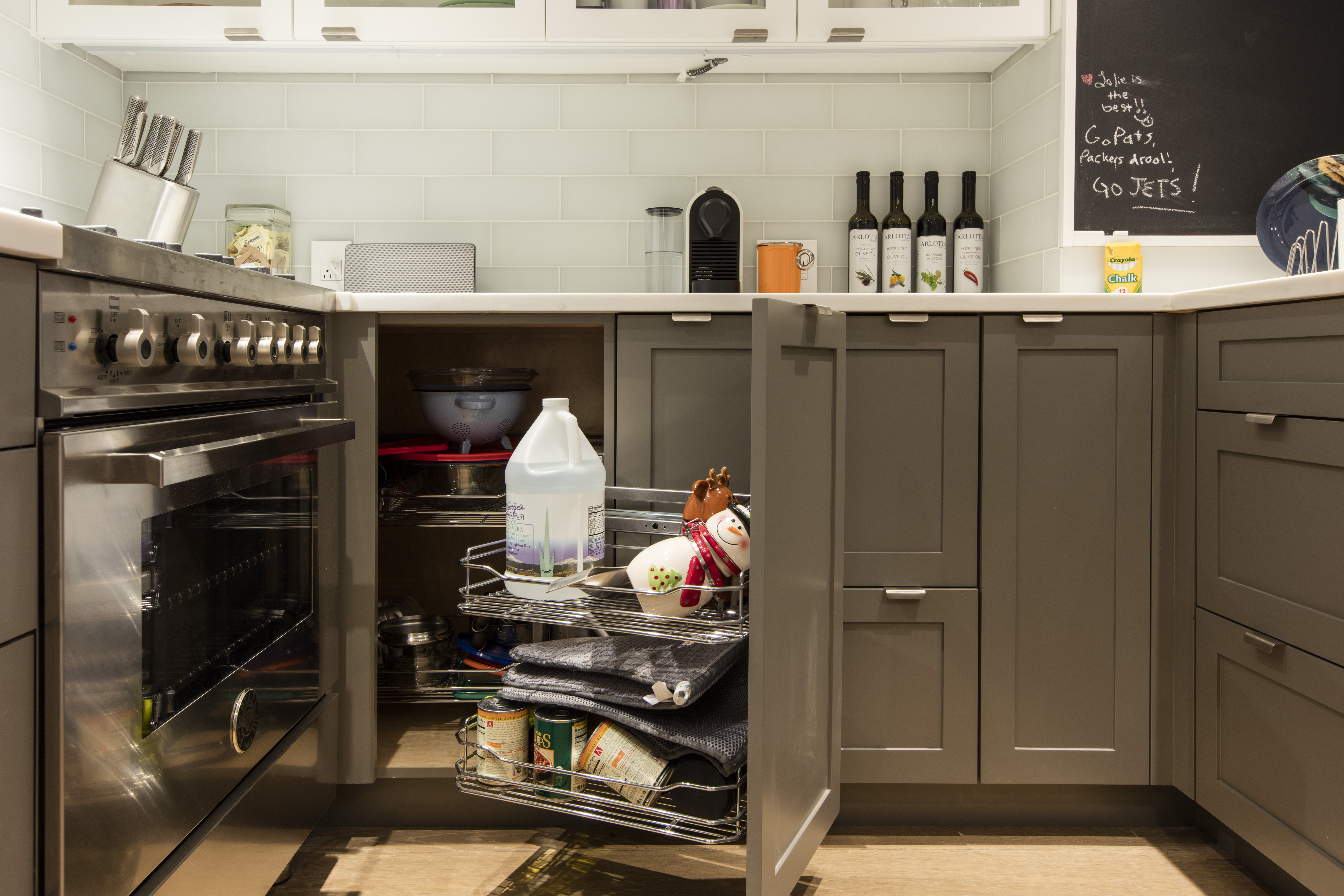 Kitchen with taupe Shaker cabinets, pull-out rack, and subway tile backsplash