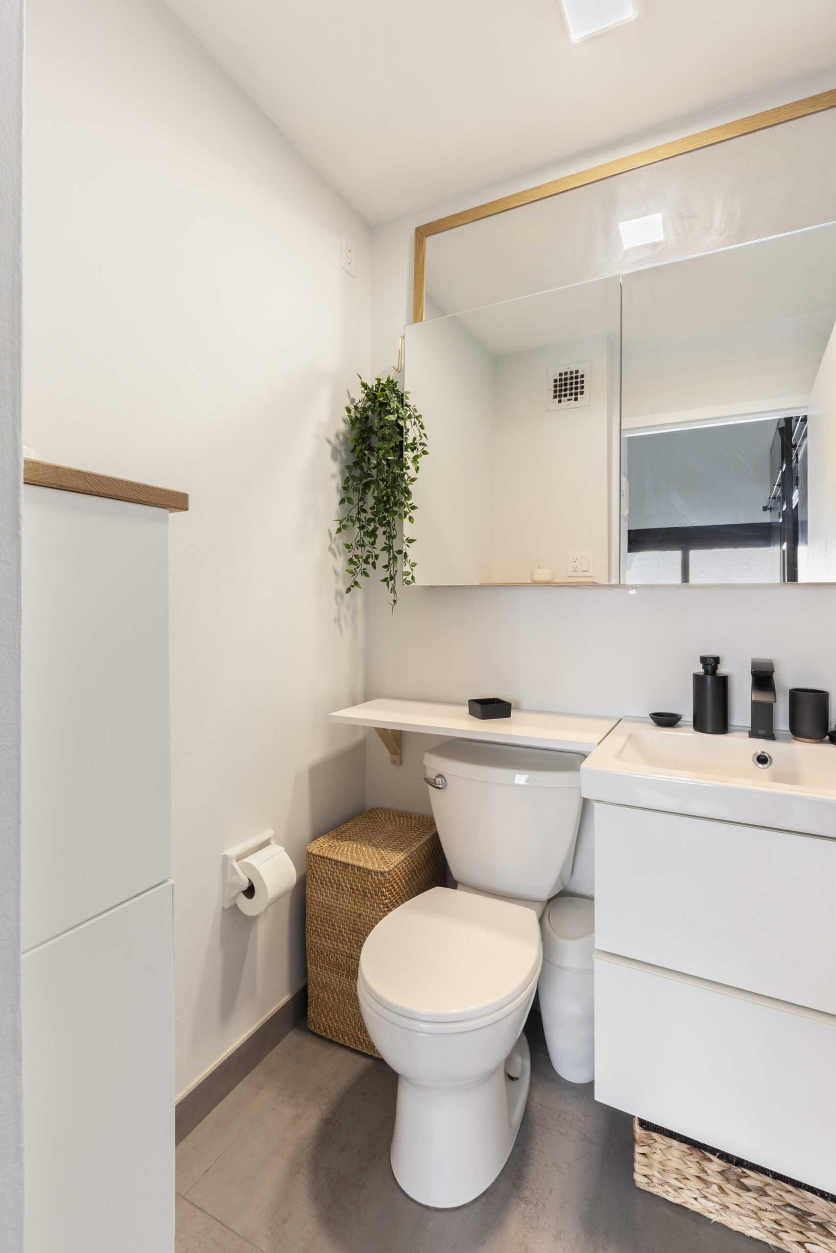 Renovated bathroom of a studio loft with white fixtures and overhead lighting