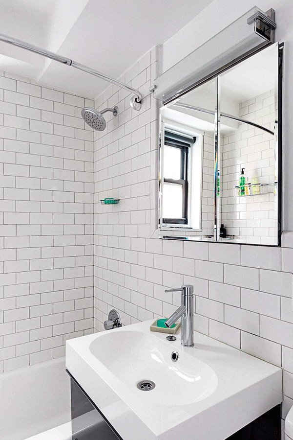 Remodeled bathroom with medicine cabinet, white subway tile, and black vanity