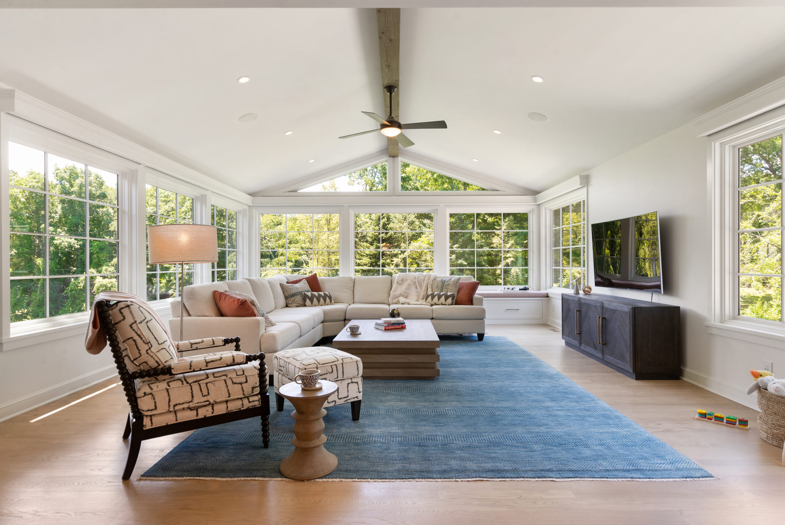 A family room addition with wide windows that created a bright gathering space in her Westchester home